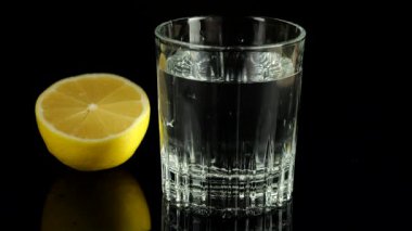 Bir dilim limon bir bardak suya düşer. Yavaş çekim.