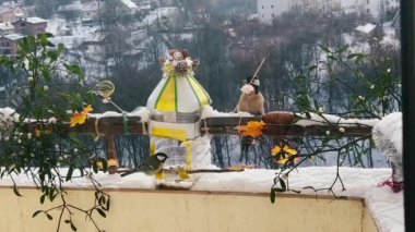 Woodpecker and great tits eats a piece of bacon and salo, pumpkin and sunflower seeds from a handmade feeder make from a plastic bottle on the balcony in winter.