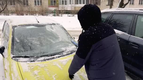 Чоловік Розчищає Машину Від Снігу Під Час Снігової Бурі — стокове відео