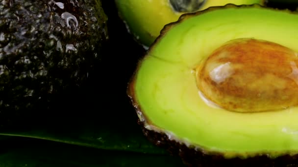 水滴落在鳄梨果实上 叶子在黑色的背景上 健康食品 — 图库视频影像