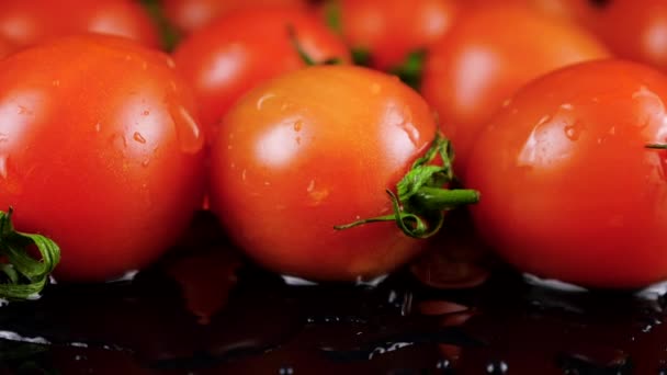 一滴水滴落在黑色背景的樱桃番茄上 — 图库视频影像