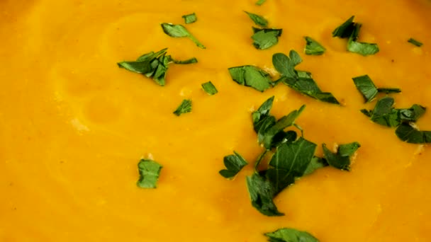 切られたパセリは純粋なカボチャのスープが付いている粘土ボウルに落ちます — ストック動画