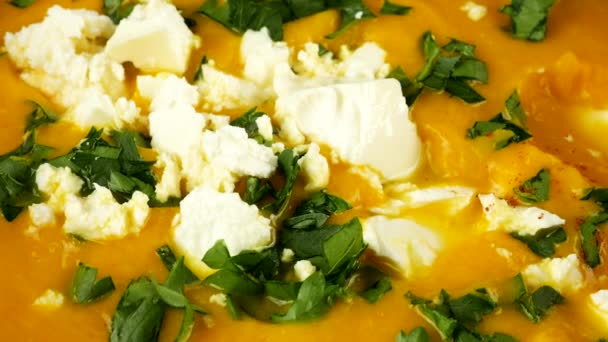 スイートパプリカはチーズとパセリの純粋なカボチャスープと粘土ボウルに注ぎ込まれています — ストック動画