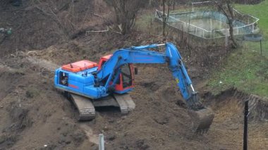 LVIV, UKRAINE - 15 Mart 2024: Crawler kazı alanı kazar ve bir bina inşaatı için bir alan oluşturur.