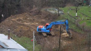 LVIV, UKRAINE - 15 Mart 2024: Crawler kazı alanı kazar ve bir bina inşaatı için bir alan oluşturur.