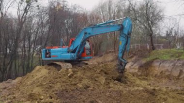 LVIV, UKRAINE - 15 Mart 2024: Crawler kazı alanı kazar ve bir bina inşaatı için bir alan oluşturur.