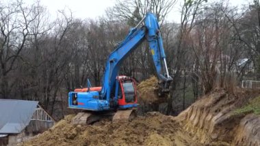 LVIV, UKRAINE - 15 Mart 2024: Crawler kazı alanı kazar ve bir bina inşaatı için bir alan oluşturur.