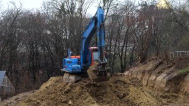 LVIV, UKRAINE - 15 Mart 2024: Crawler kazı alanı kazar ve bir bina inşaatı için bir alan oluşturur.