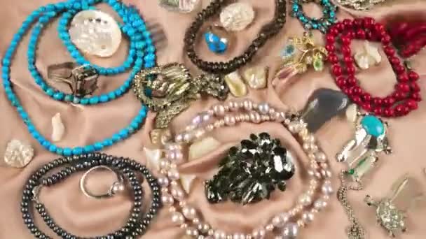 Κοσμήματα Από Πολύτιμες Πέτρες Και Μαργαριτάρια Μπεζ Φόντο Μεταξιού Κάτω — Αρχείο Βίντεο