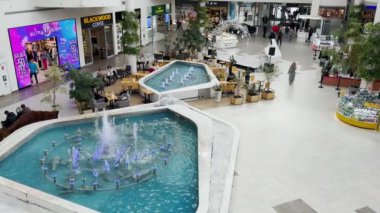 LVIV, UKRAINE - 25 Mart 2024: Modern bir alışveriş ve eğlence merkezinde çeşmeleri olan açık bir alanın üst görüntüsü.