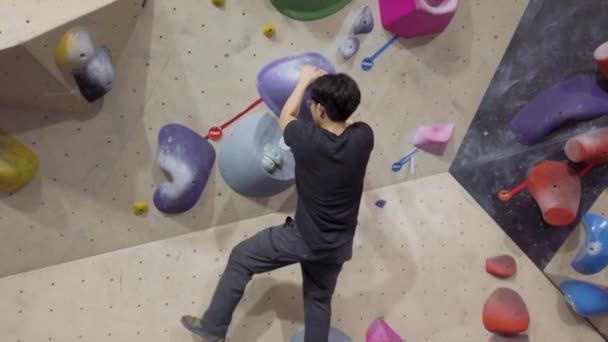 亚洲攀登者爬上健身馆室外卵石墙 在室内积极参加体育活动 — 图库视频影像