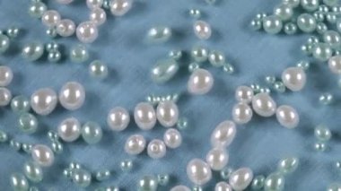 Mavi arka planda, suyun altında beyaz ve mavi inciler. Temiz suyun yüzeyinde dalgalanmalar.