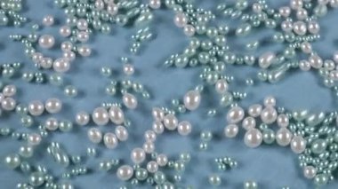 Mavi arka planda, suyun altında beyaz ve mavi inciler. Temiz suyun yüzeyinde dalgalanmalar.