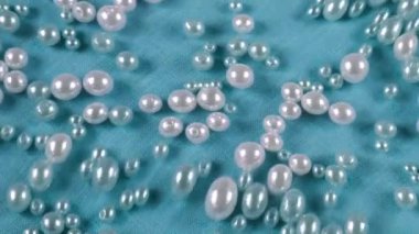 Mavi arka planda, suyun altında beyaz ve mavi inciler. Temiz suyun yüzeyinde dalgalanmalar.