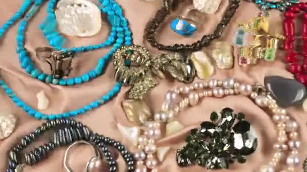 Schmuck Aus Edelsteinen Und Perlen Auf Beigem Seidengrund Unter Wasser — Stockvideo