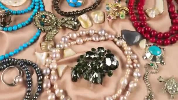 Schmuck Aus Edelsteinen Und Perlen Auf Beigem Seidengrund Unter Wasser — Stockvideo