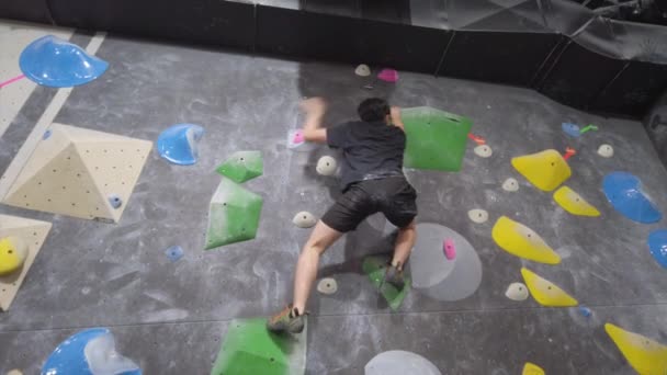 亚洲攀登者爬上健身馆室外卵石墙 在室内积极参加体育活动 — 图库视频影像