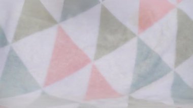 Doldurulmuş ve pofuduk Pembe Piliç peluş oyuncak yumuşak bir bebek battaniyesine düşer. Yavaş çekim.