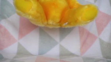 Doldurulmuş ve pofuduk oyuncak ayı yumuşak bir bebek battaniyesine düşer. Yavaş çekim.