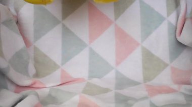 Doldurulmuş ve pofuduk oyuncak ayılar yumuşak bir bebek battaniyesine düşerler. Yavaş çekim.