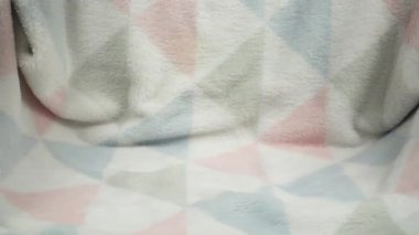 Amerikan bayrağı renginde oyuncak bir ayı yumuşak bir bebek battaniyesinin üzerine düşer. Yavaş çekim.