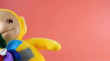 Uzaylı oyuncağı pembe arka planda oynuyor ve dans ediyor..