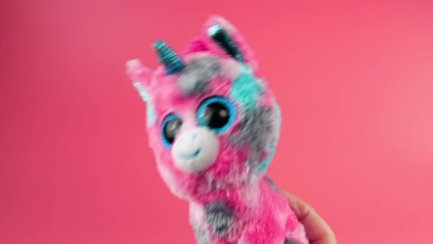 毛绒绒玩具粉红独角兽在粉红的背景上嬉戏跳舞 免版税图库视频片段