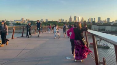 Vistula üzerindeki bisiklet ve yaya köprüsü. 31 Mayıs 2024, Vistula. İnsanlar selfie çekip şehrin ve nehrin arka planına karşı fotoğraf çekiyorlar..