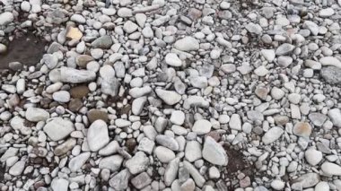 Çakıl taşlı bir dağ nehrinin kıyısında. Kayalık dibi ve berrak suyu olan sığ bir dağ nehri. Nehir kıyısında bir kız duruyor.