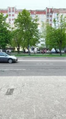 Evlerin ve yolların arka planında dolu taneleri yağıyor. Ağır çekim. Dikey video.
