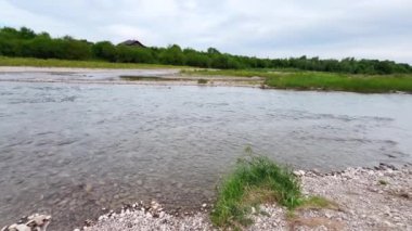 Kayalık dibi ve berrak suyu olan sığ bir dağ nehri..