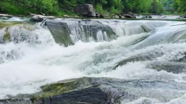 Bir dağ nehrinin fırtınalı suları ve şelaleleri.