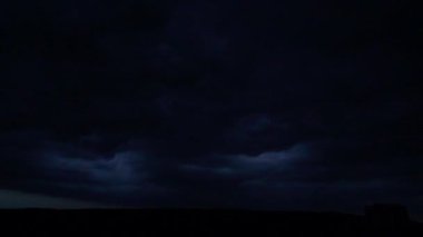 Gece gökyüzünde şimşekler çakar gök gürültüsü bulutları arasında.