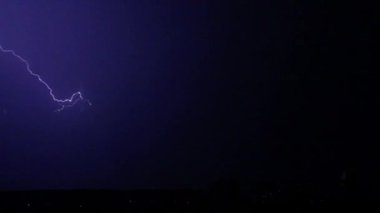 Gece gökyüzünde şimşekler çakar gök gürültüsü bulutları arasında.