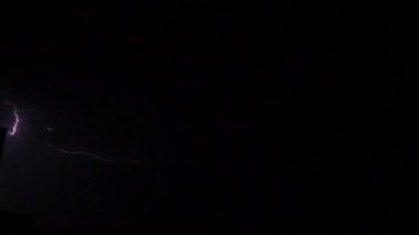 Gece gökyüzünde şimşekler çakar gök gürültüsü bulutları arasında.