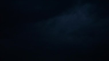 Gece gökyüzünde şimşekler çakar gök gürültüsü bulutları arasında.