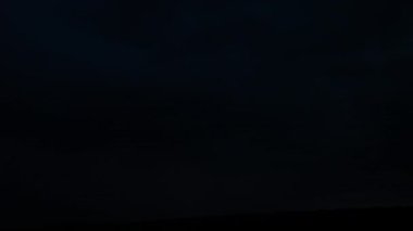 Gece gökyüzünde şimşekler çakar gök gürültüsü bulutları arasında.