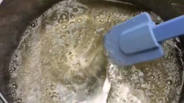 Metal bir tavada kaynatılmış şeker pekmezi. Yavaş çekim.