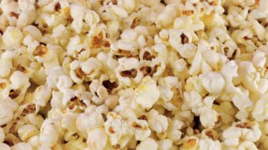 Döner patlamış mısır taneleri. Patlamış mısır arka planı. Makro ve yakın plan.