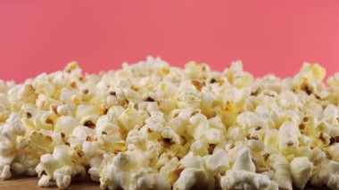 Pembe arka planda dönen patlamış mısır taneleri. Makro ve yakın plan.