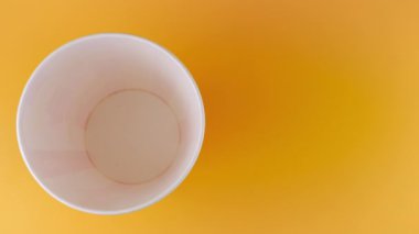 Patlamış mısır taneleri şeftali arka planda izole edilmiş kırmızı ve beyaz çizgili kovaya düşer. Atıştırmalık film, fast food kafe tatlı aperatif. Üst Manzara. Yavaş çekim.