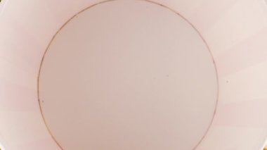 Patlamış mısır taneleri arka plandaki patlamış mısır tanelerinin üzerine kırmızı ve beyaz çizgili kovaya düşüyor. Atıştırmalık film, fast food kafe tatlı aperatif. Yavaş çekim.