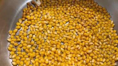 Patlamış mısır taneleri sebze yağında kızartılır ve metal bir tavanın dibinde patlar..