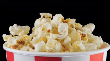 Patlamış mısır taneleri kırmızı ve beyaz çizgili kovada dönüyor. Atıştırmalık film, fast food kafe tatlı aperatif. Alfa kanalı dahil.