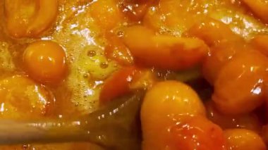 Metal bir tavada kayısı reçeli yapma süreci. Reçel tavada pişiyor..