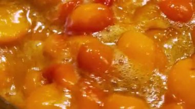 Metal bir tavada kayısı reçeli yapma süreci. Reçel tavada pişiyor..