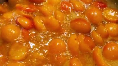 Metal bir tavada kayısı reçeli yapma süreci. Reçel tavada pişiyor..