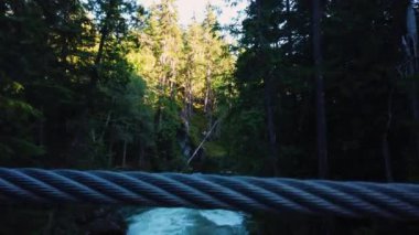 Whistler 'da, Cheakamus Nehri' nden geçmişteki tren harabelerine akan suların üzerindeki asma köprü boyunca, ormandaki terk edilmiş harabelere doğru inanılmaz bir yürüyüş yolu var. Whistler, British Columbia, Kanada.
