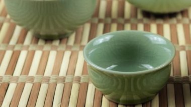 Seramik chawanları bir gaiwan 'dan gelen sıcak suyla ısıtıyorum. Doğu Asya tarzı çay seremonisi. Yavaş çekim.