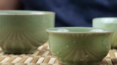 Seramik chawanları bir gaiwan 'dan gelen sıcak suyla ısıtıyorum. Doğu Asya tarzı çay seremonisi.